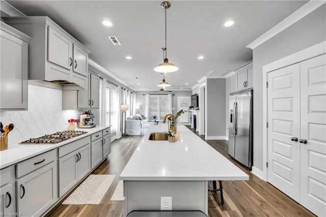 5166 Whaitley Ln, Greensboro, NC 27407 - kitchen featuring a sink, appliances with stainless steel finishes, crown molding, open floor plan, and a center island with sink