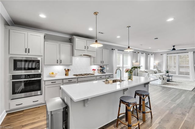 5166 Whaitley Ln, Greensboro, NC 27407 - kitchen with appliances with stainless steel finishes, a sink, a kitchen bar, light countertops, and decorative backsplash
