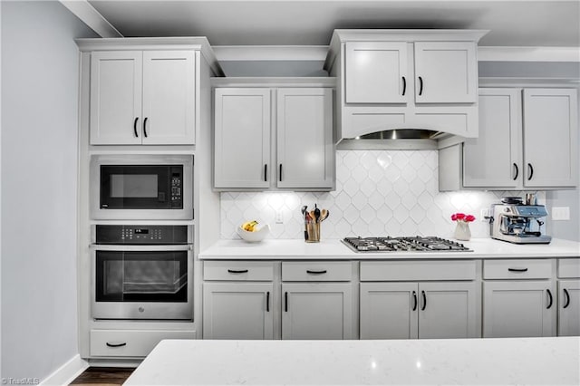 5166 Whaitley Ln, Greensboro, NC 27407 - kitchen featuring appliances with stainless steel finishes, decorative backsplash, baseboards, and dark wood-type flooring