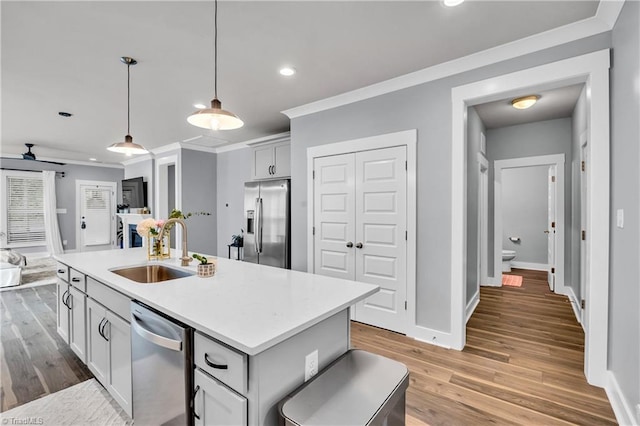 5166 Whaitley Ln, Greensboro, NC 27407 - kitchen featuring a sink, stainless steel appliances, open floor plan, ornamental molding, and light countertops