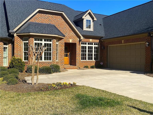 view of front of property with concrete driveway, an attached garage, brick siding, and a shingled roof