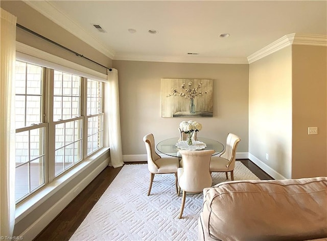 dining room featuring crown molding, wood finished floors, visible vents, and baseboards