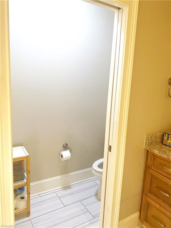 bathroom with baseboards and toilet