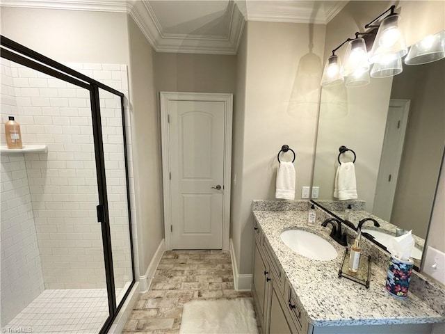 bathroom featuring vanity, crown molding, baseboards, and a stall shower