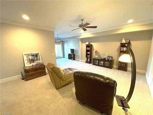 living area with baseboards, light colored carpet, ornamental molding, and a ceiling fan