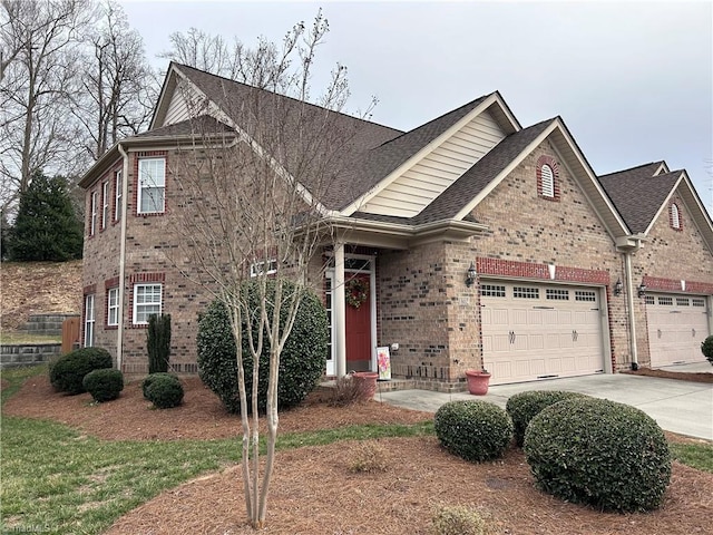 view of front facade featuring brick siding, a garage, driveway, and a shingled roof