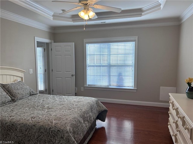 bedroom with a tray ceiling, baseboards, dark wood-style flooring, and crown molding