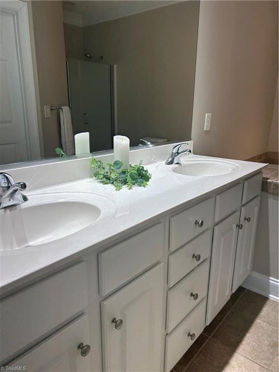 bathroom featuring a sink, walk in shower, double vanity, and tile patterned flooring