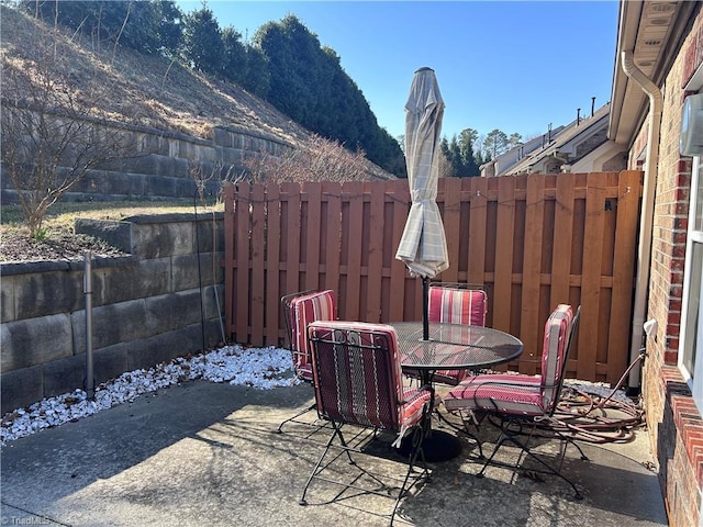 view of patio featuring outdoor dining area and fence