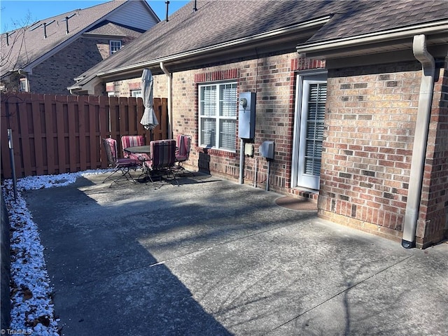 view of patio featuring central AC, outdoor dining space, and fence