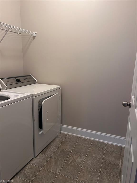 laundry area featuring baseboards, laundry area, and washer and clothes dryer