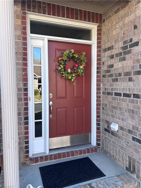 doorway to property with brick siding