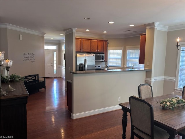 kitchen featuring stainless steel appliances, dark wood-style floors, brown cabinetry, and ornamental molding