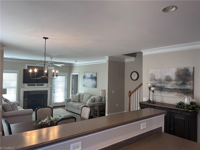 living area featuring an inviting chandelier, ornamental molding, and a fireplace