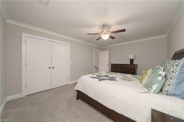 bedroom featuring ornamental molding, light colored carpet, a closet, and ceiling fan