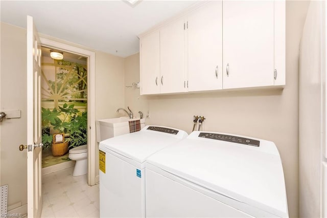 washroom featuring washer and dryer, baseboards, light floors, a sink, and cabinet space