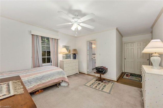 bedroom with baseboards, ornamental molding, a ceiling fan, and a closet