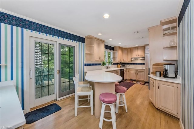 kitchen featuring light countertops, open shelves, a breakfast bar, and light wood-type flooring