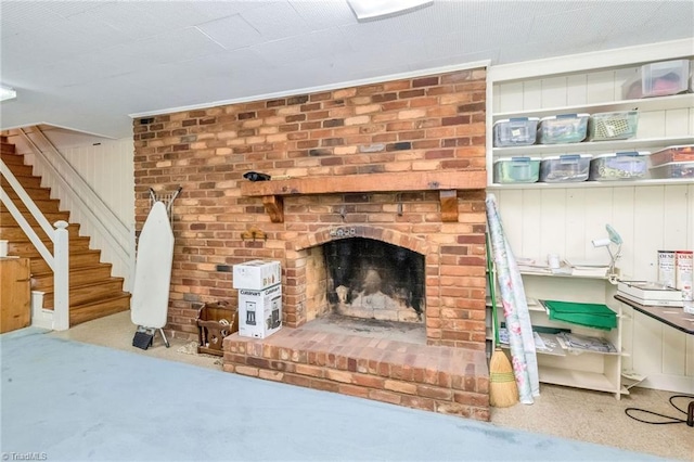 carpeted living area with stairway and a fireplace