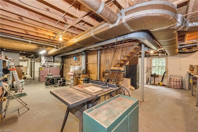 below grade area featuring heating unit and stairway