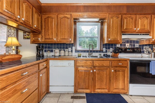 kitchen with light tile patterned floors, white appliances, sink, and tasteful backsplash