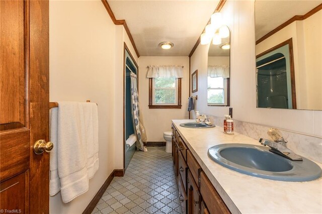 bathroom with ornamental molding, vanity, toilet, and curtained shower