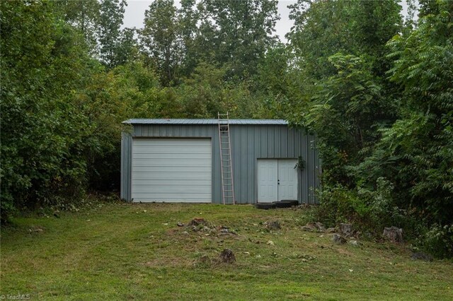 view of outdoor structure featuring a yard and a garage