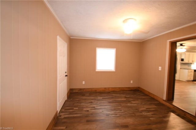 empty room featuring crown molding, dark hardwood / wood-style floors, and a textured ceiling