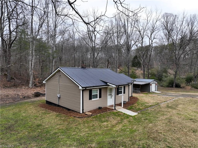 view of front of property featuring a garage, an outdoor structure, and a front yard