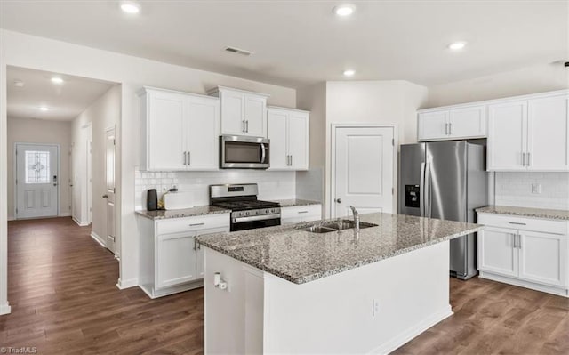 kitchen featuring appliances with stainless steel finishes, white cabinetry, a kitchen island with sink, and sink