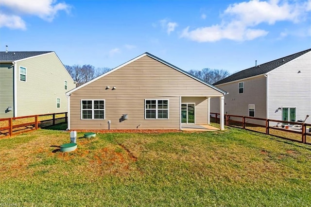 rear view of house with a patio and a lawn