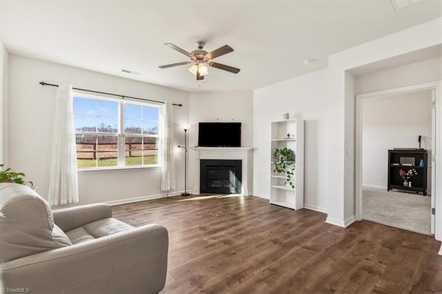 living room featuring ceiling fan and dark hardwood / wood-style flooring