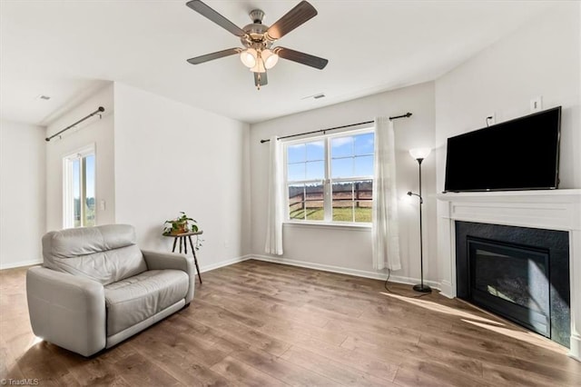 sitting room featuring hardwood / wood-style flooring, ceiling fan, and a healthy amount of sunlight