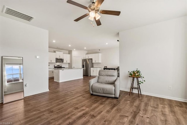 living area featuring ceiling fan and dark hardwood / wood-style flooring