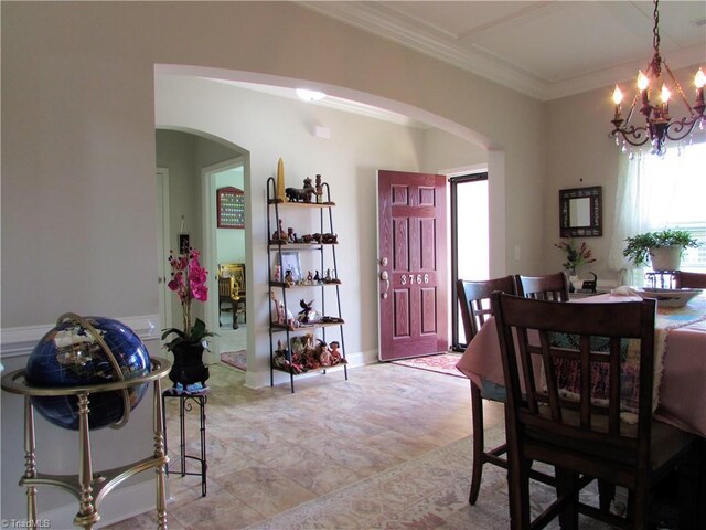 dining room featuring arched walkways, a chandelier, and crown molding