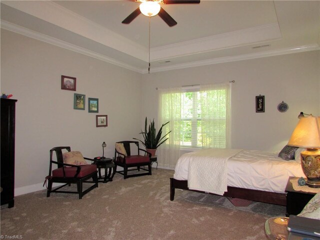 bedroom with a tray ceiling, carpet flooring, ornamental molding, and baseboards