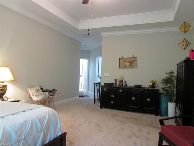 carpeted bedroom with a tray ceiling, ornamental molding, and ceiling fan