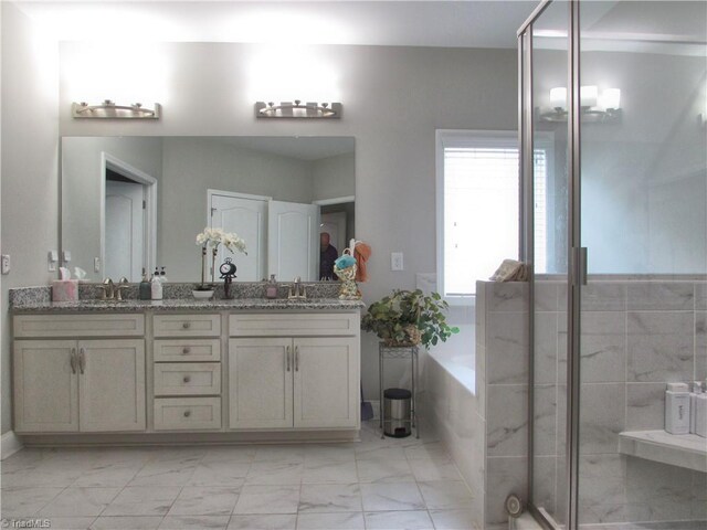 bathroom with marble finish floors, a bath, double vanity, and a stall shower