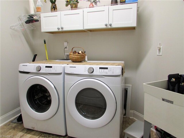 laundry area featuring cabinet space, washer and clothes dryer, and baseboards
