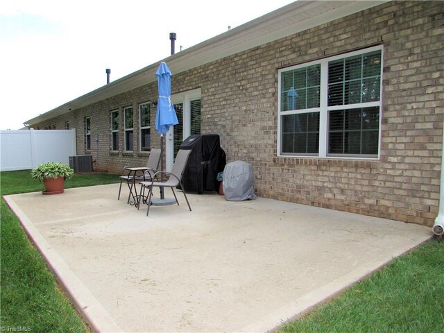 view of patio with fence, grilling area, and central AC