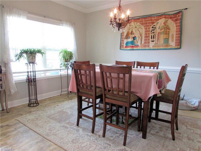 dining space with crown molding, a chandelier, and baseboards