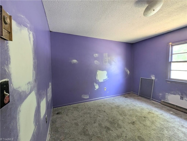 carpeted empty room with a textured ceiling and baseboards