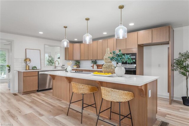 kitchen with a center island, dishwasher, sink, and hanging light fixtures