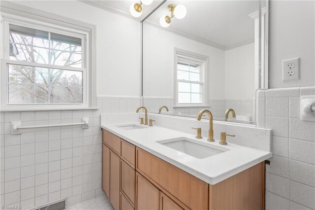 bathroom featuring vanity, crown molding, and tile walls