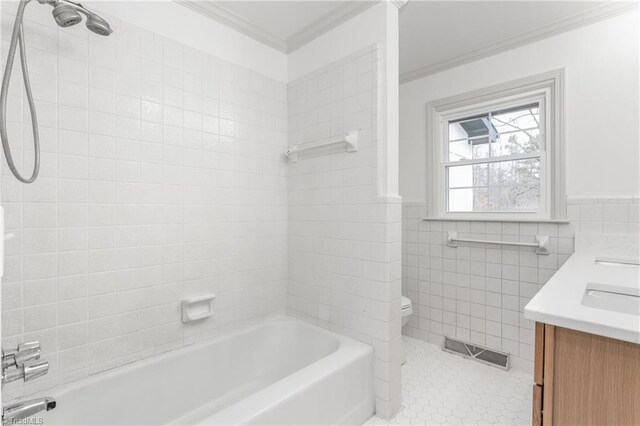 full bathroom with crown molding, tiled shower / bath, tile walls, vanity, and tile patterned flooring