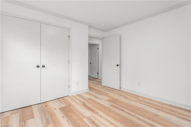 unfurnished bedroom featuring ornamental molding, light hardwood / wood-style floors, and a closet