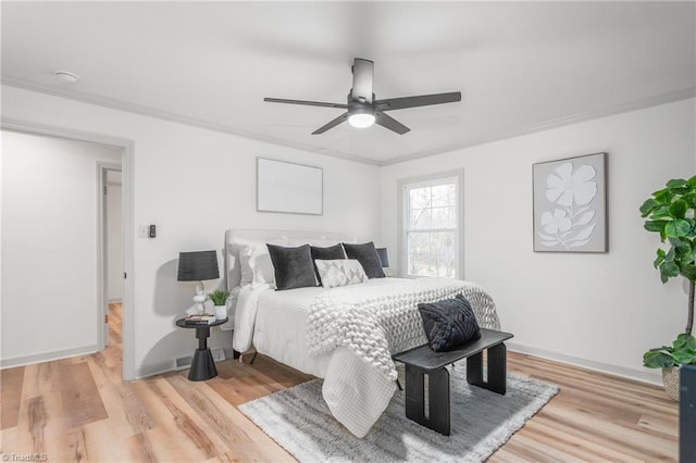 bedroom with crown molding, ceiling fan, and light wood-type flooring