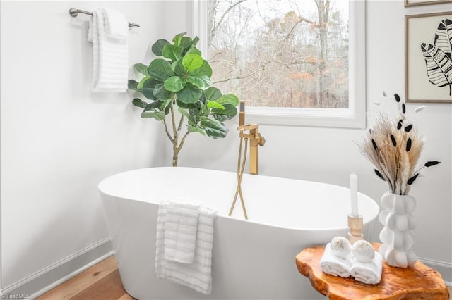 bathroom with a washtub and hardwood / wood-style floors
