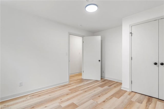 unfurnished bedroom featuring light hardwood / wood-style floors and a closet