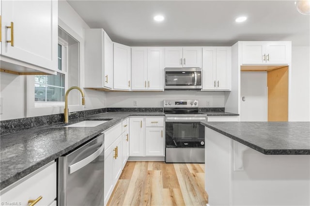 kitchen featuring stainless steel appliances, sink, and white cabinets